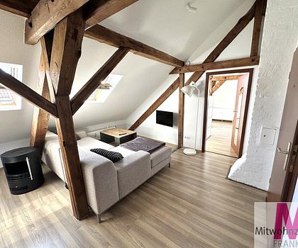 Stilvolles Wohnen unter dem Dach Hochwertig möblierte 2-Zimmer-Wohnung mit sichtbaren Holzbalken